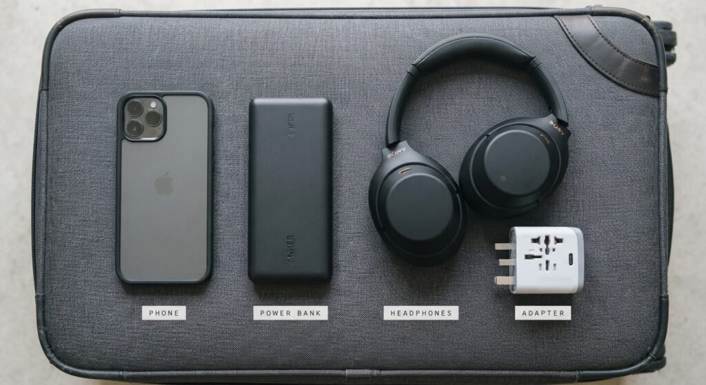 Phone, power bank, headphones, and travel adapter for a weekend trip